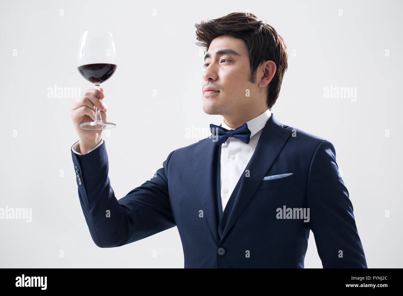 Elegant young man enjoying red wine Stock Photo - Alamy