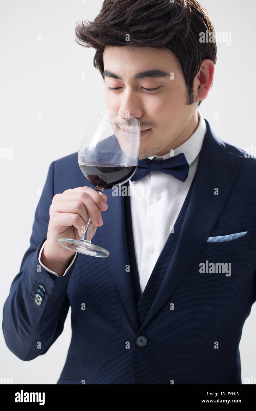 Elegant young man enjoying red wine Stock Photo - Alamy