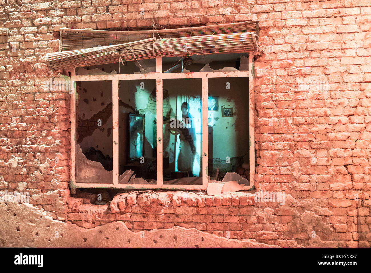Display of bullet-riddled home with projection of woman in window in ...