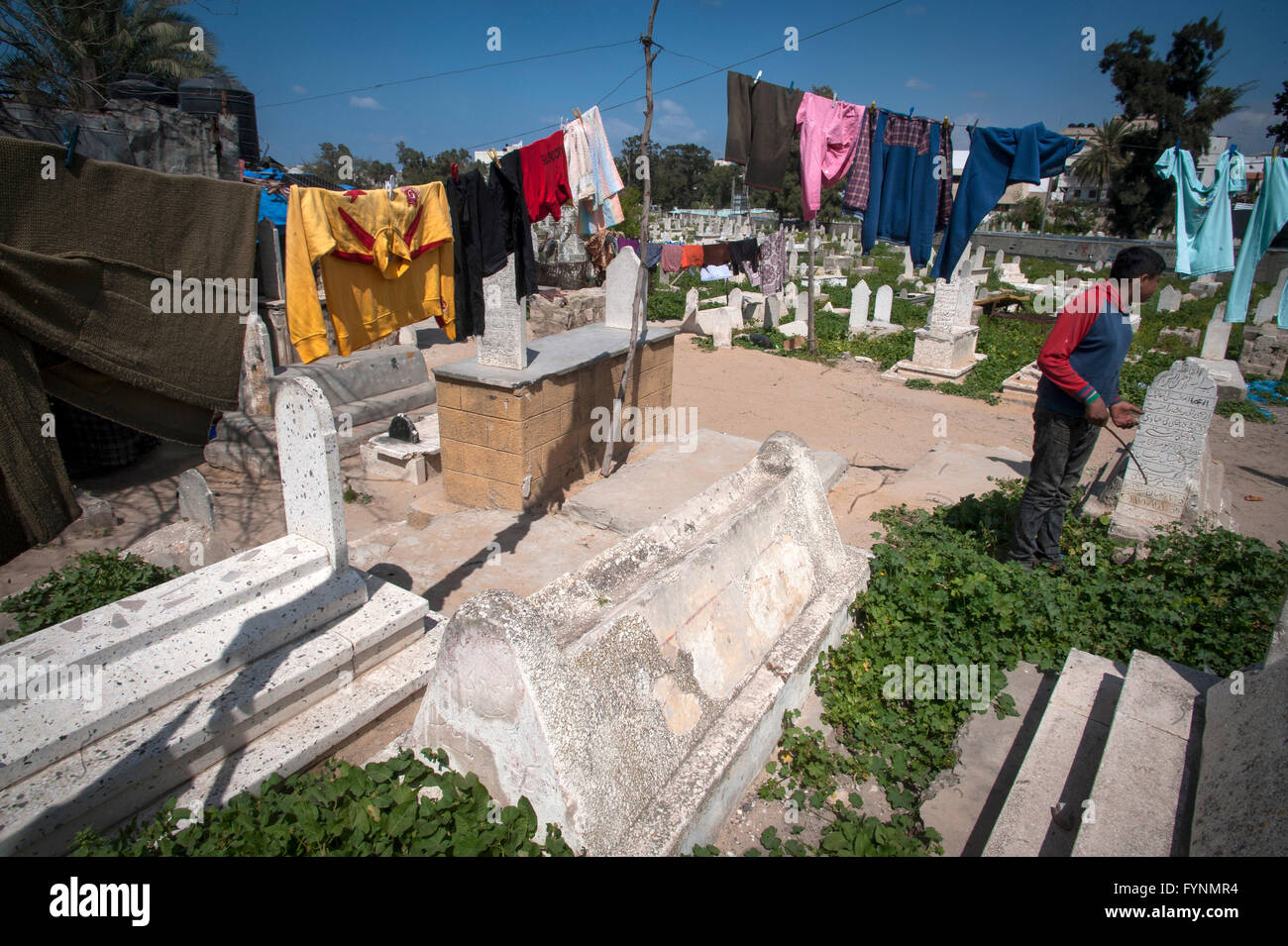 Hanging washing amongst the gravestones at el Sheikh Shaban public cemetery in Gaza City, Gaza Strip. Stock Photo