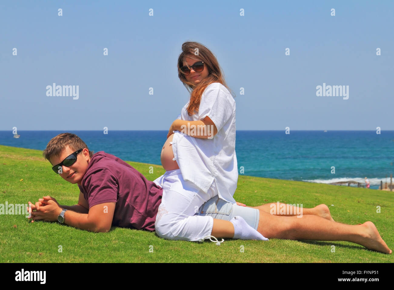 The couple relaxing on the grass by the sea Stock Photo - Alamy