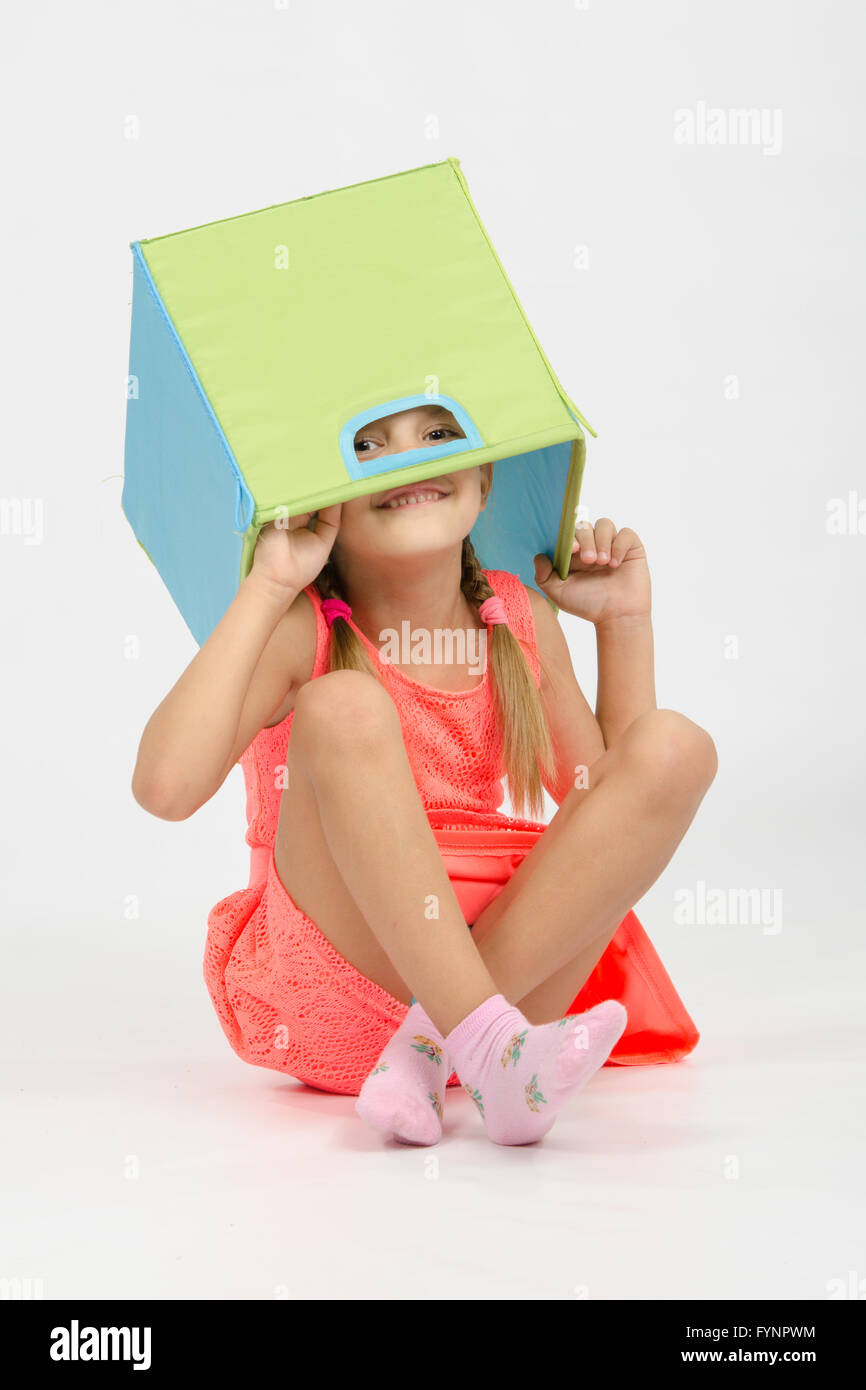 Girl indulging in a box for toys put on the head Stock Photo