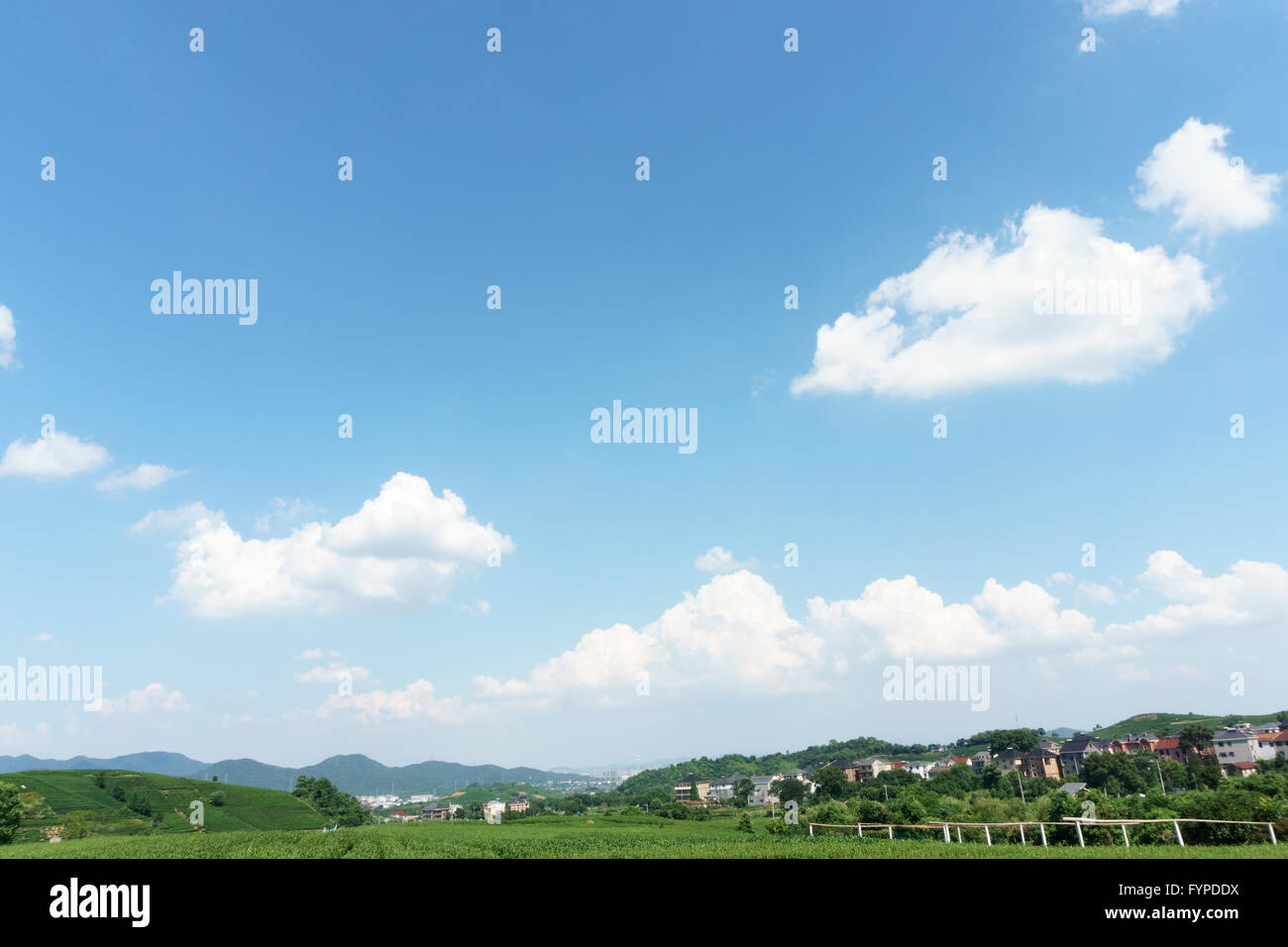 village under clear, blue sky and white clouds Stock Photo - Alamy