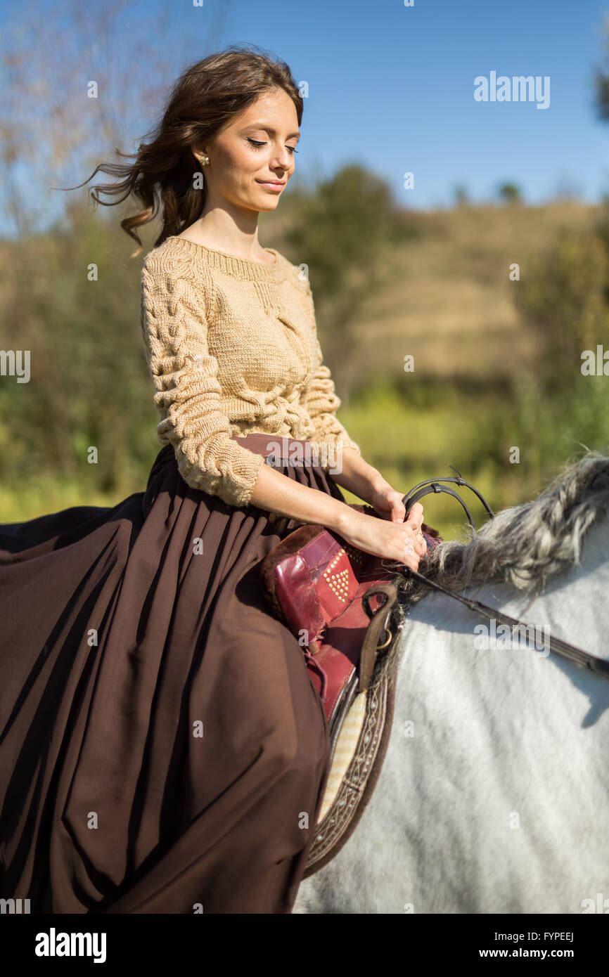 Beautiful girl riding a white horse Stock Photo