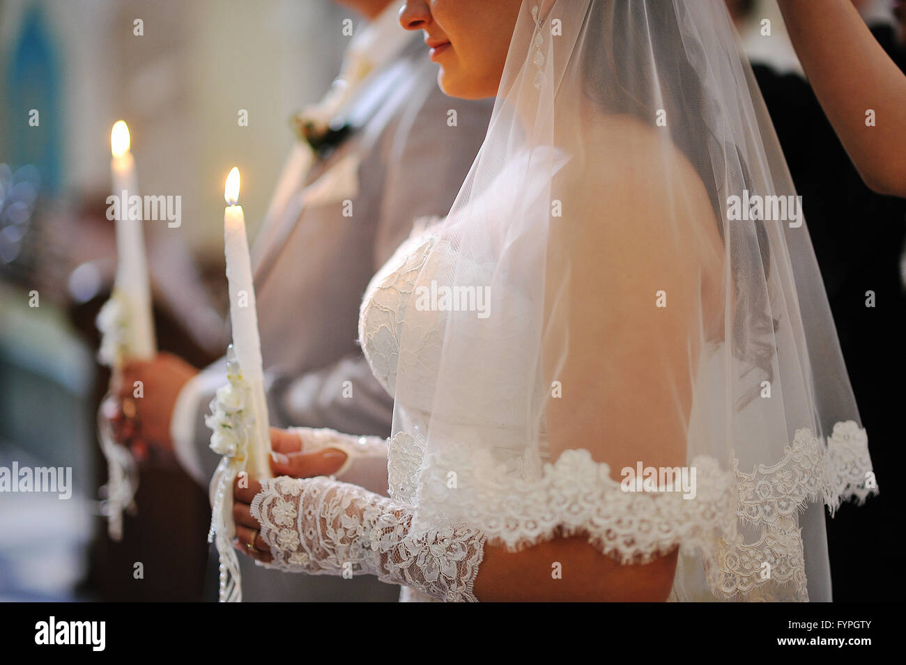 Candles at hads of newlyweds on church Stock Photo