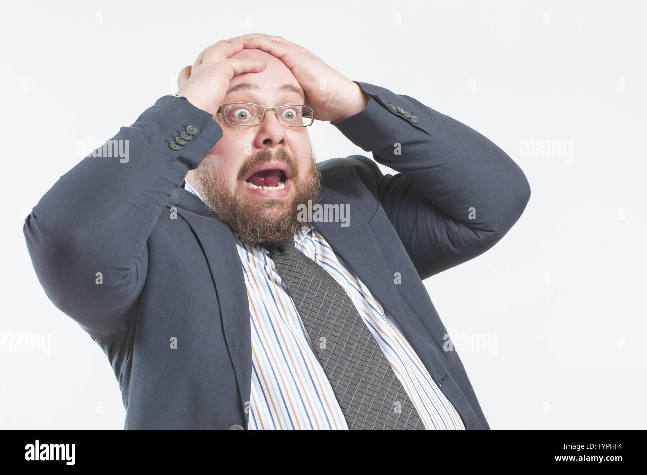 The man screams in horror holding his head. Stock Photo