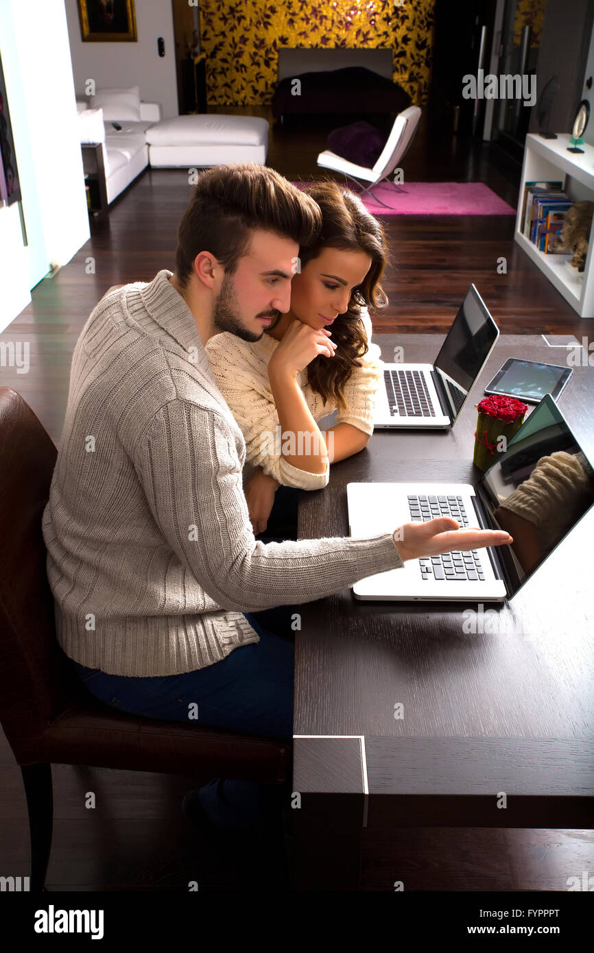 Young couple watching together some content on a laptop computer Stock  Photo - Alamy