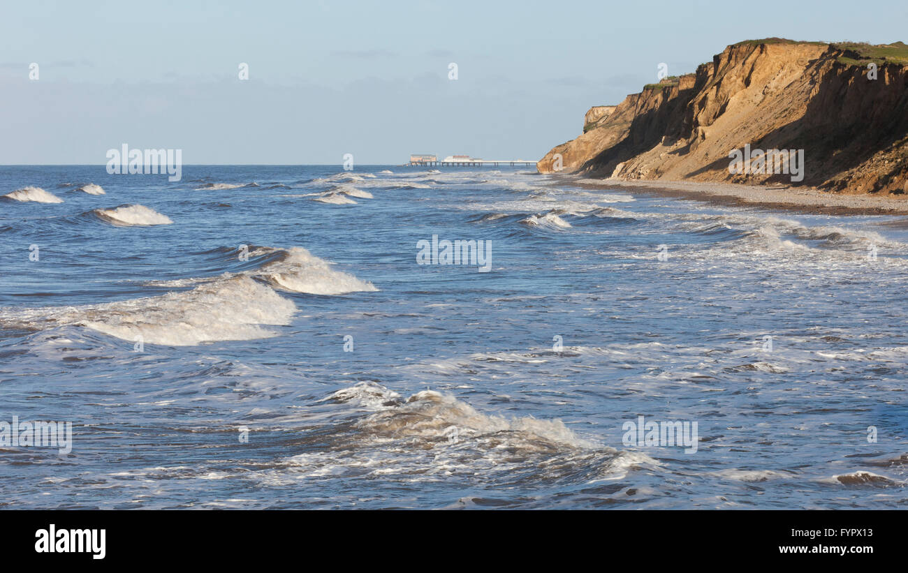 West Runton beach in evening light at high tide looking east towards Cromer Pier in north