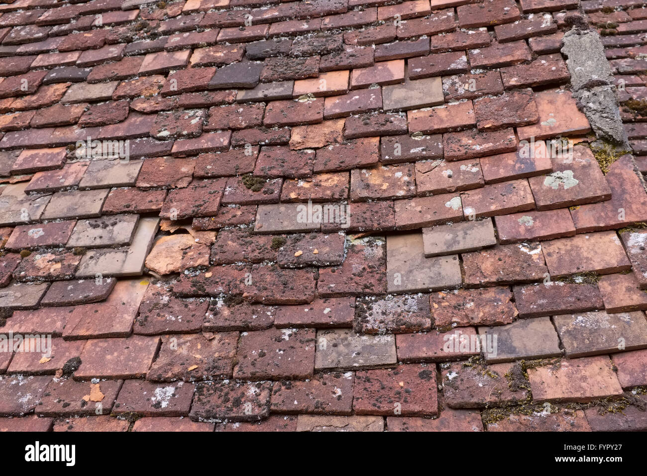 broken clay shingle tiles on an old roof in France Stock Photo