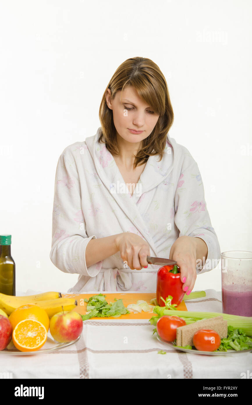 Young woman cuts sweet pepper vegetarian cooking Salad Stock Photo