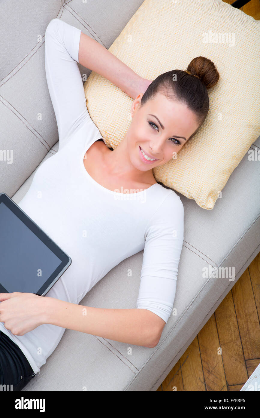 Young woman with a Tablet PC on the Sofa Stock Photo - Alamy
