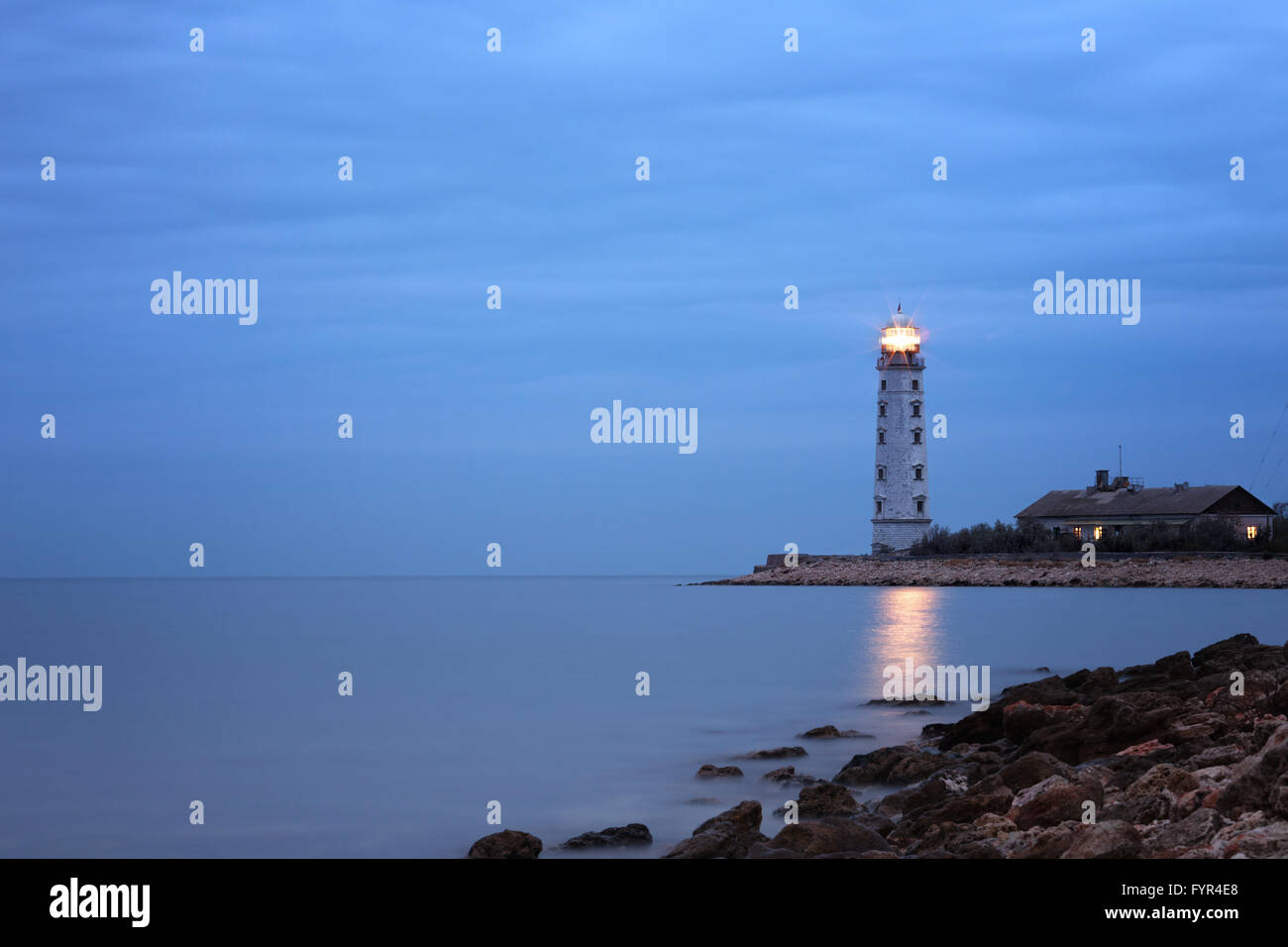 Cloudy twilight seascape with lighthouse Stock Photo