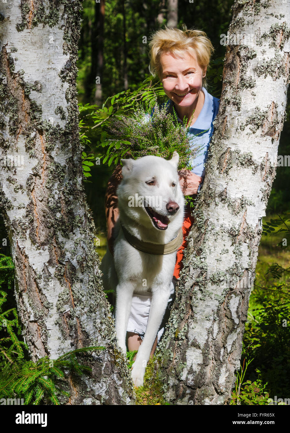Portrait of a woman with a dog on a walk in the woods Stock Photo