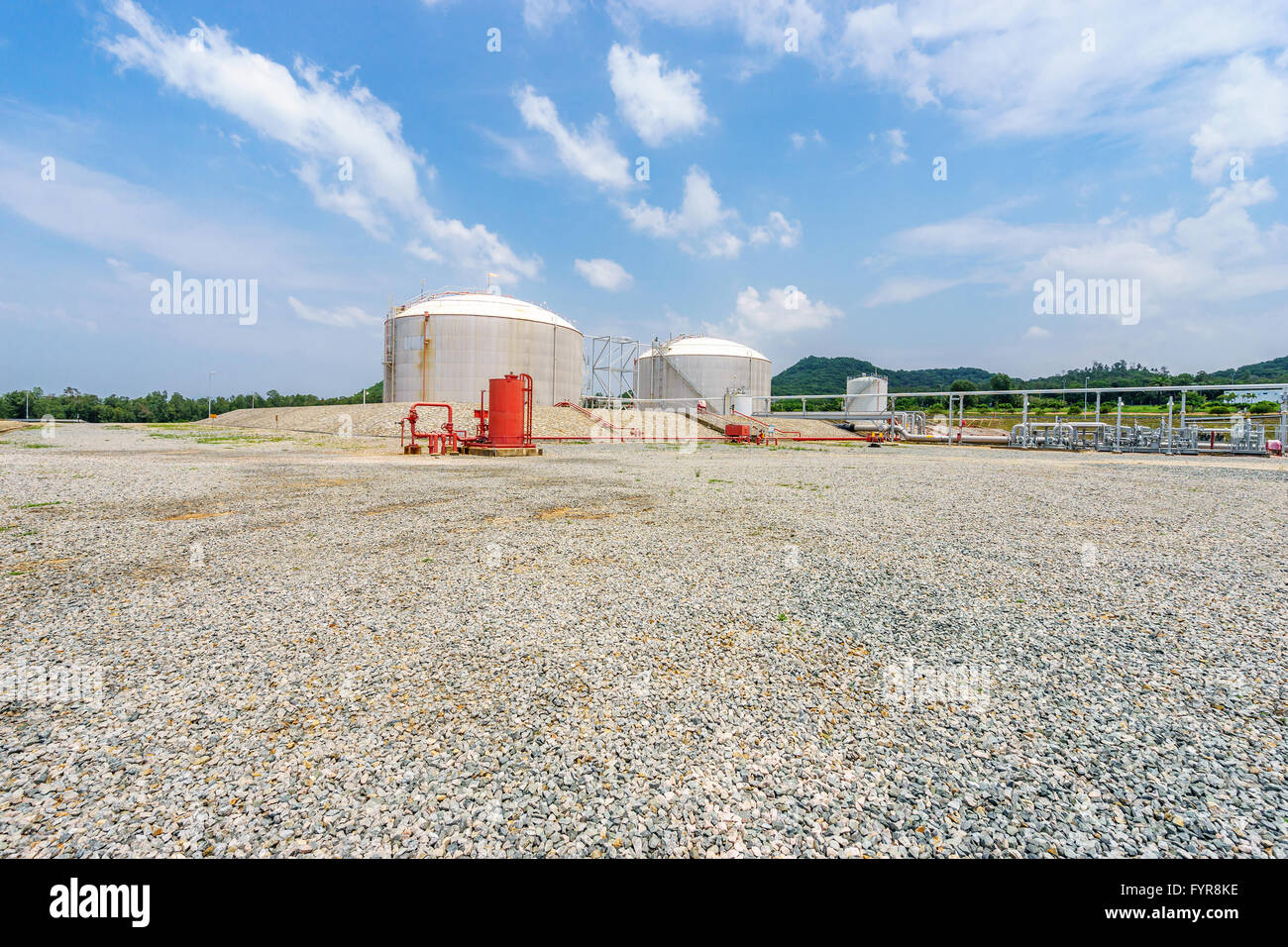 oil tanks stand in empty ground in blue sky Stock Photo