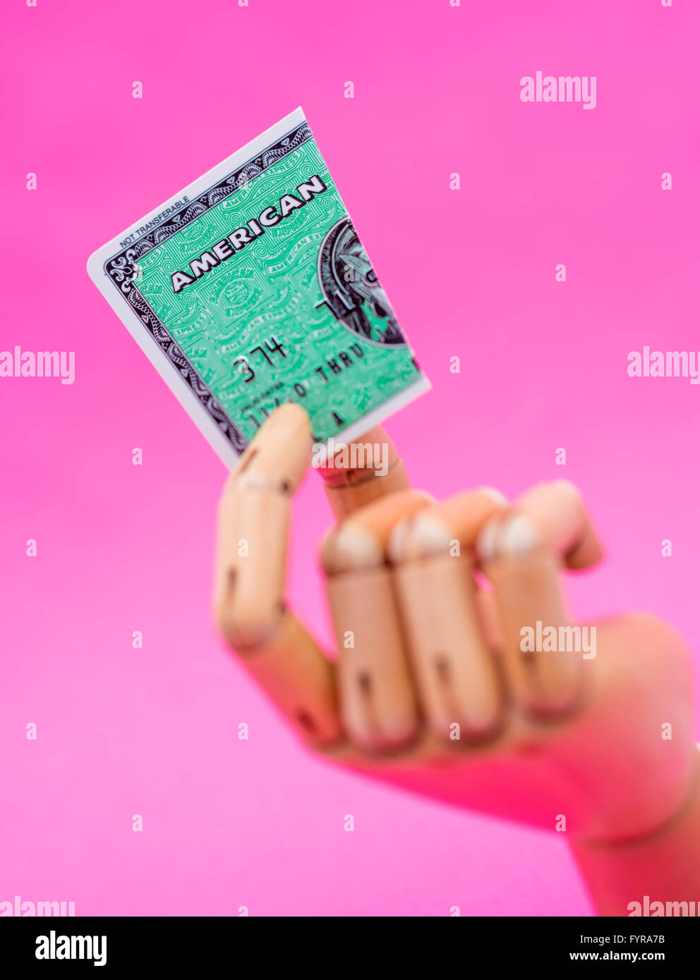 Wooden mannequin hand holding an American Express card that has been cut in half Stock Photo