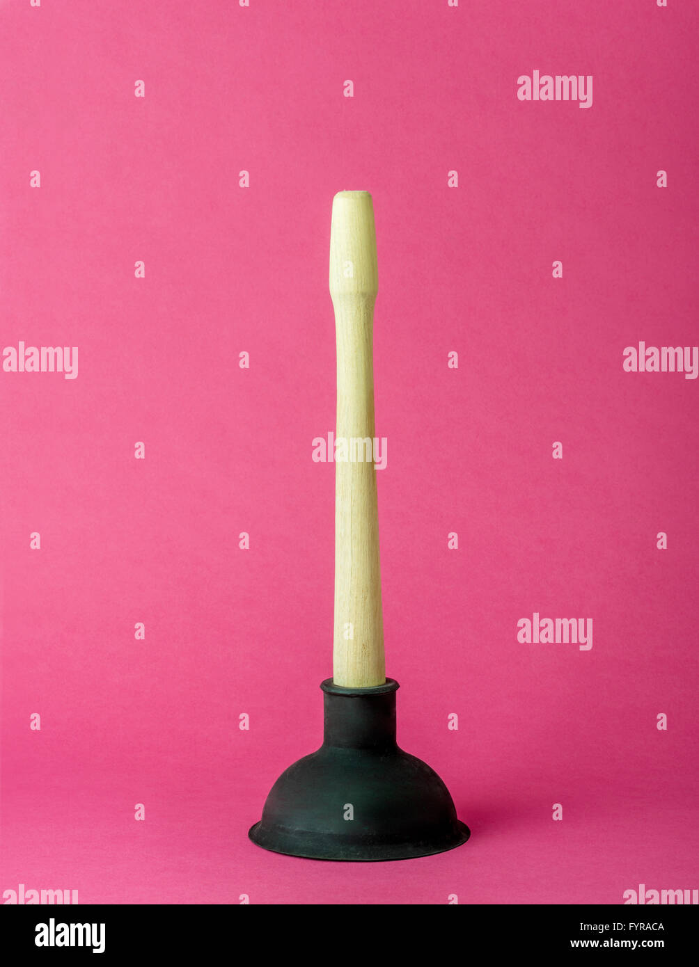 Wooden and rubber sink plunger on pink background Stock Photo