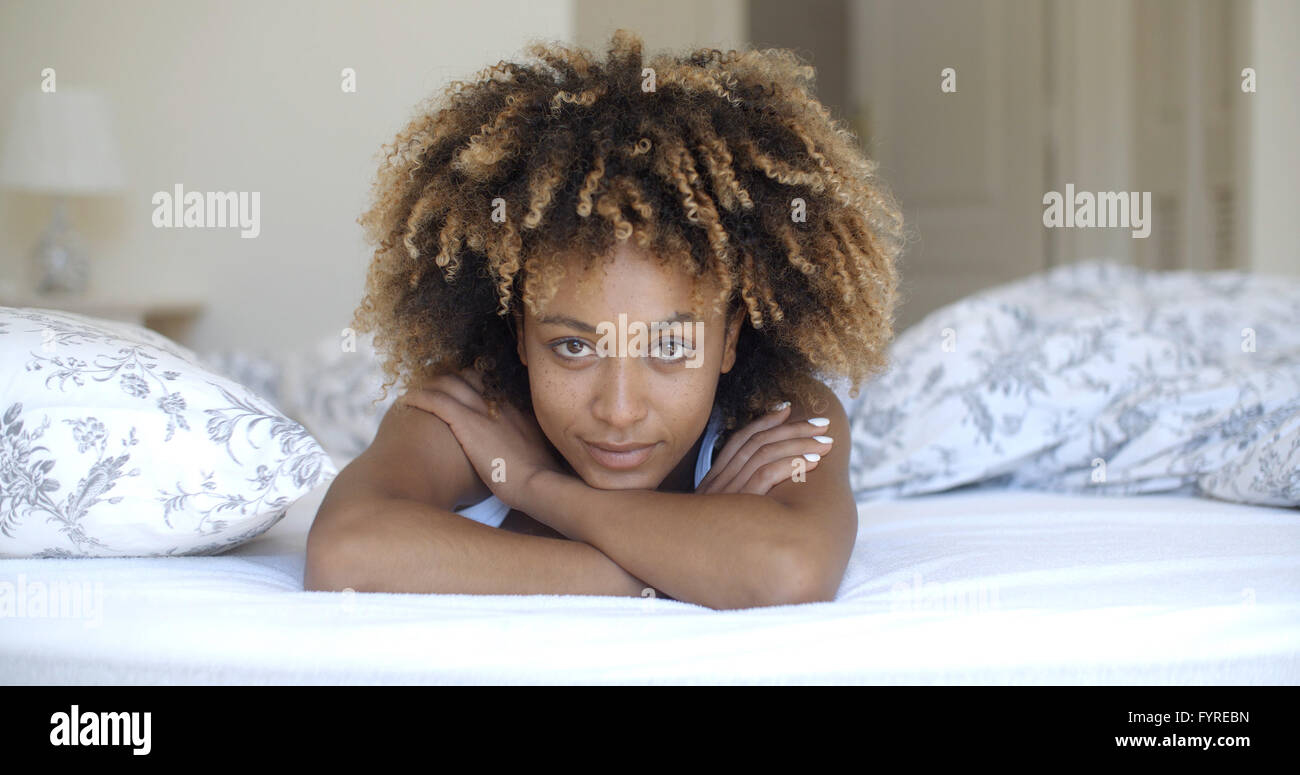 Cute woman lying on bed at home in bedroom Stock Photo