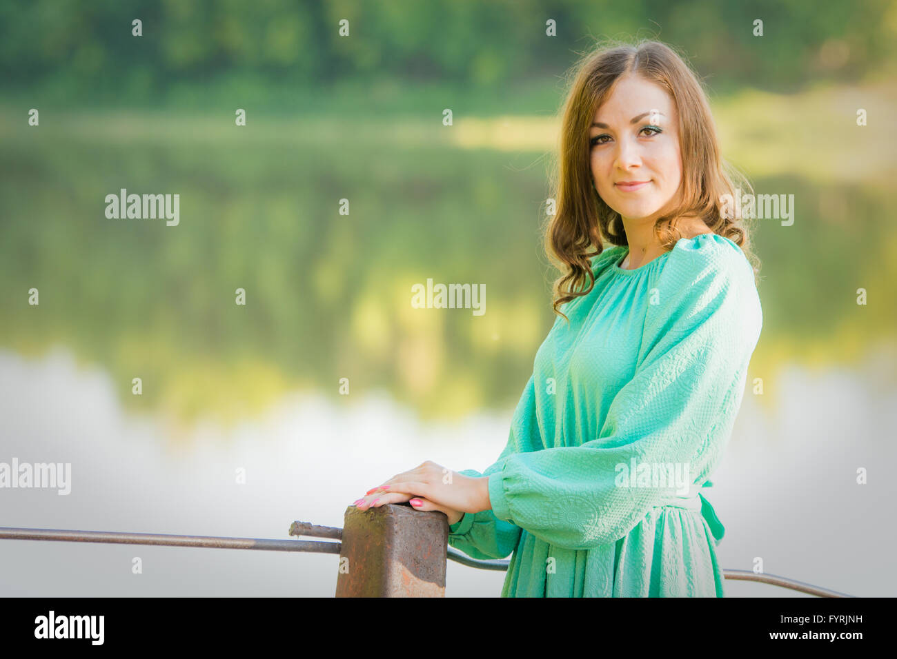 Portrait of a girl on the bridge over the river in the early morning ...
