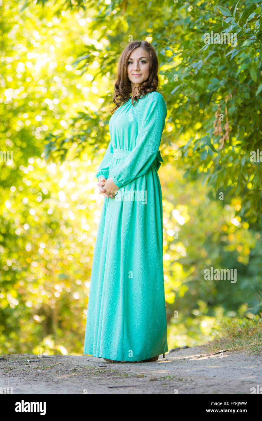A girl in a long dress against a background of blurred forest Stock Photo