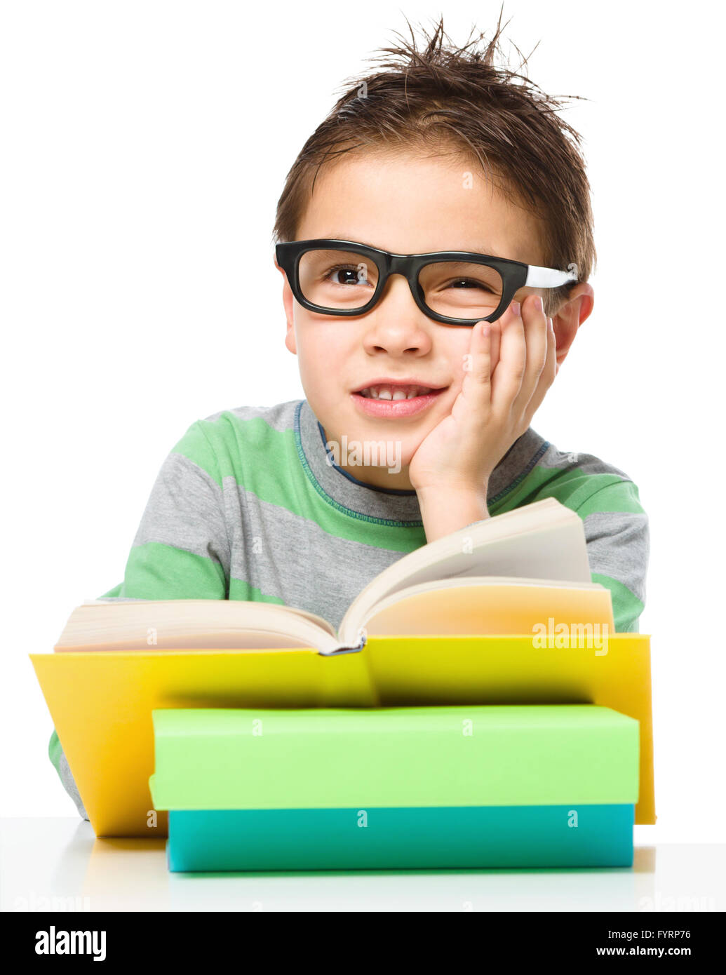 Cute little boy is reading a book while wearing glasses supporting his ...