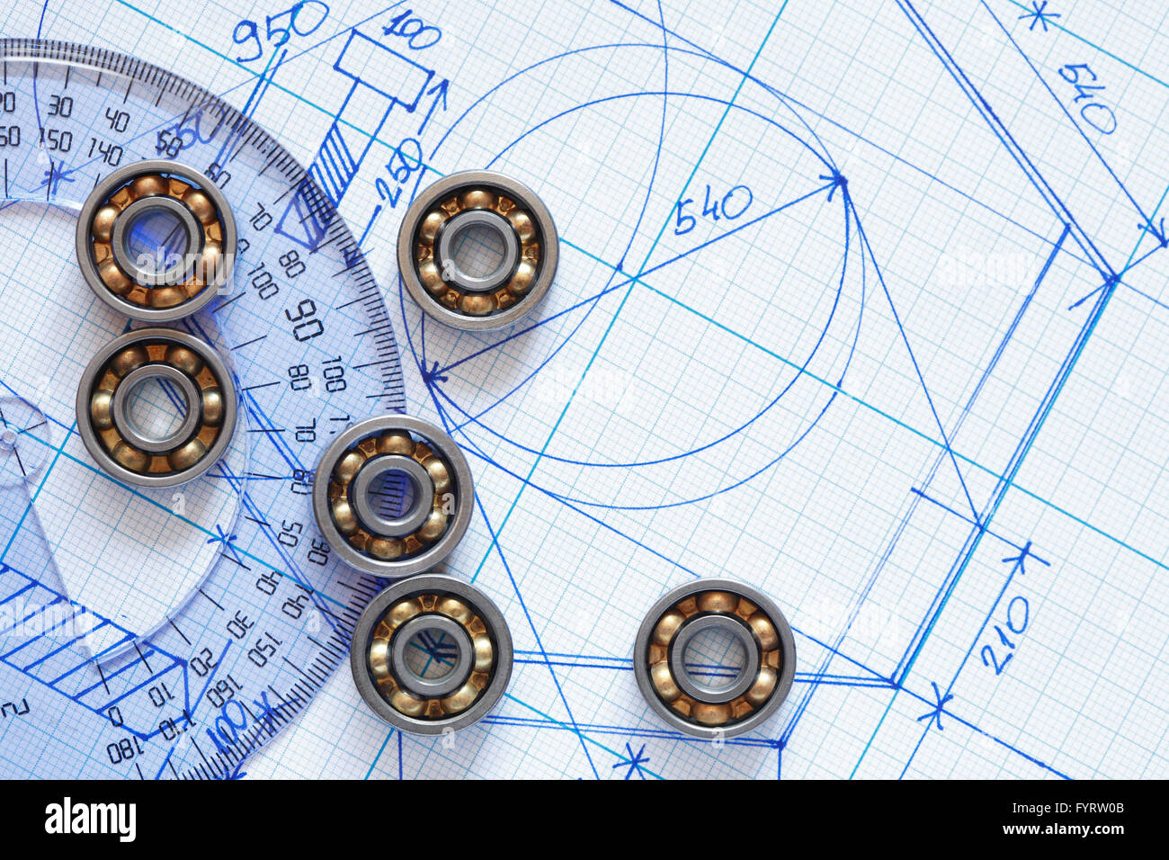 Industrial concept. Few ballbearings near ruler on graph paper background Stock Photo