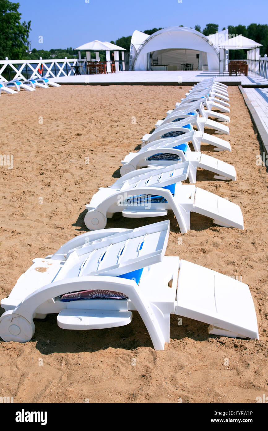 Summer vacation. Outdoor solarium with empty plastic beach chairs near