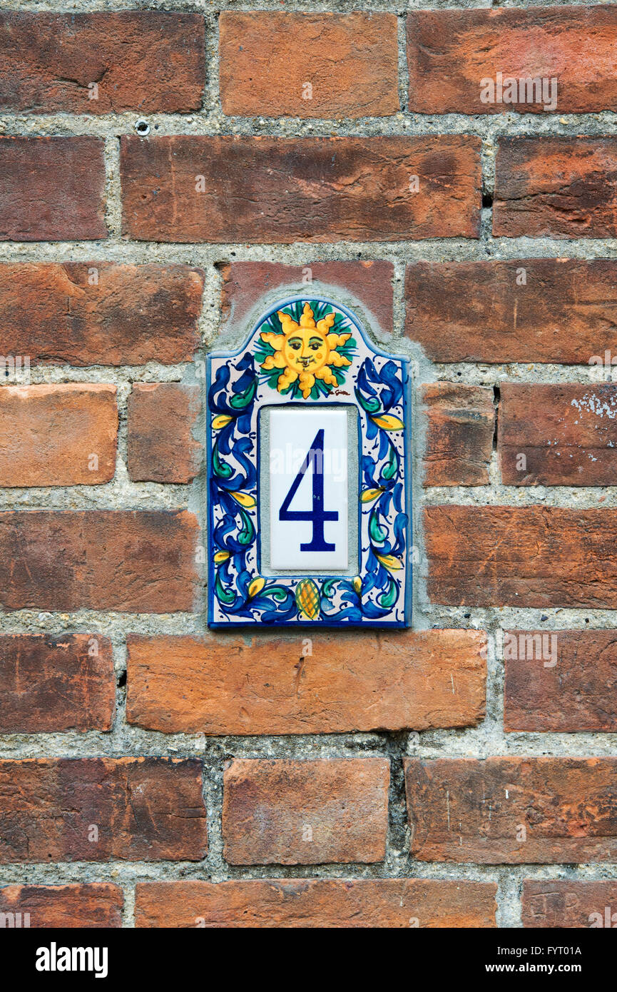 Number 4 sun house plaque on a red brick wall Stock Photo