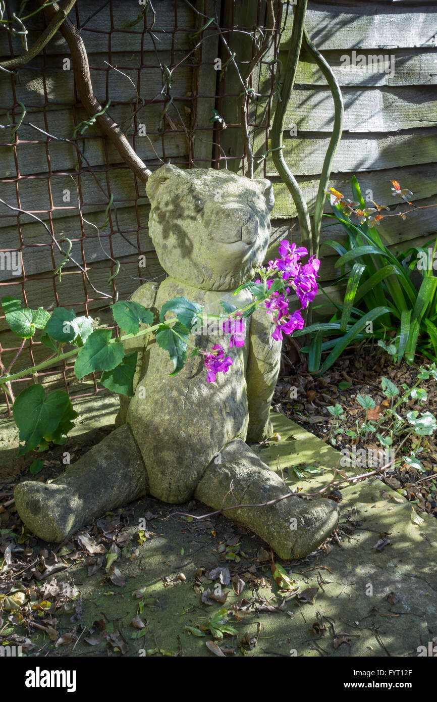 Concrete model of a teddy bear garden ornament with plants flowers