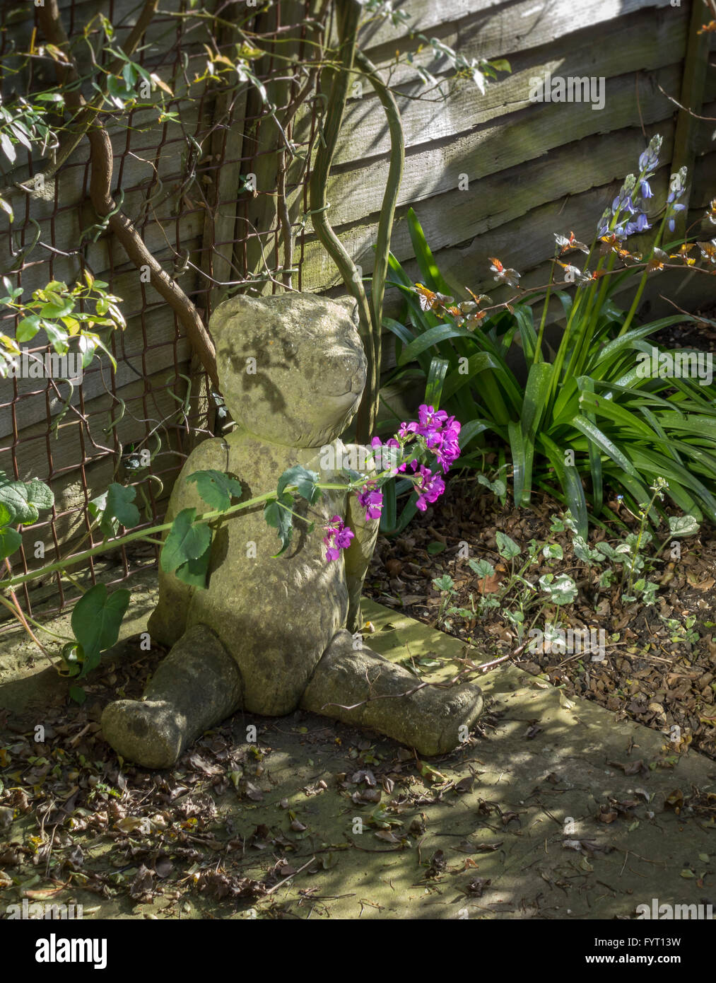 Concrete model of a teddy bear garden ornament with plants flowers