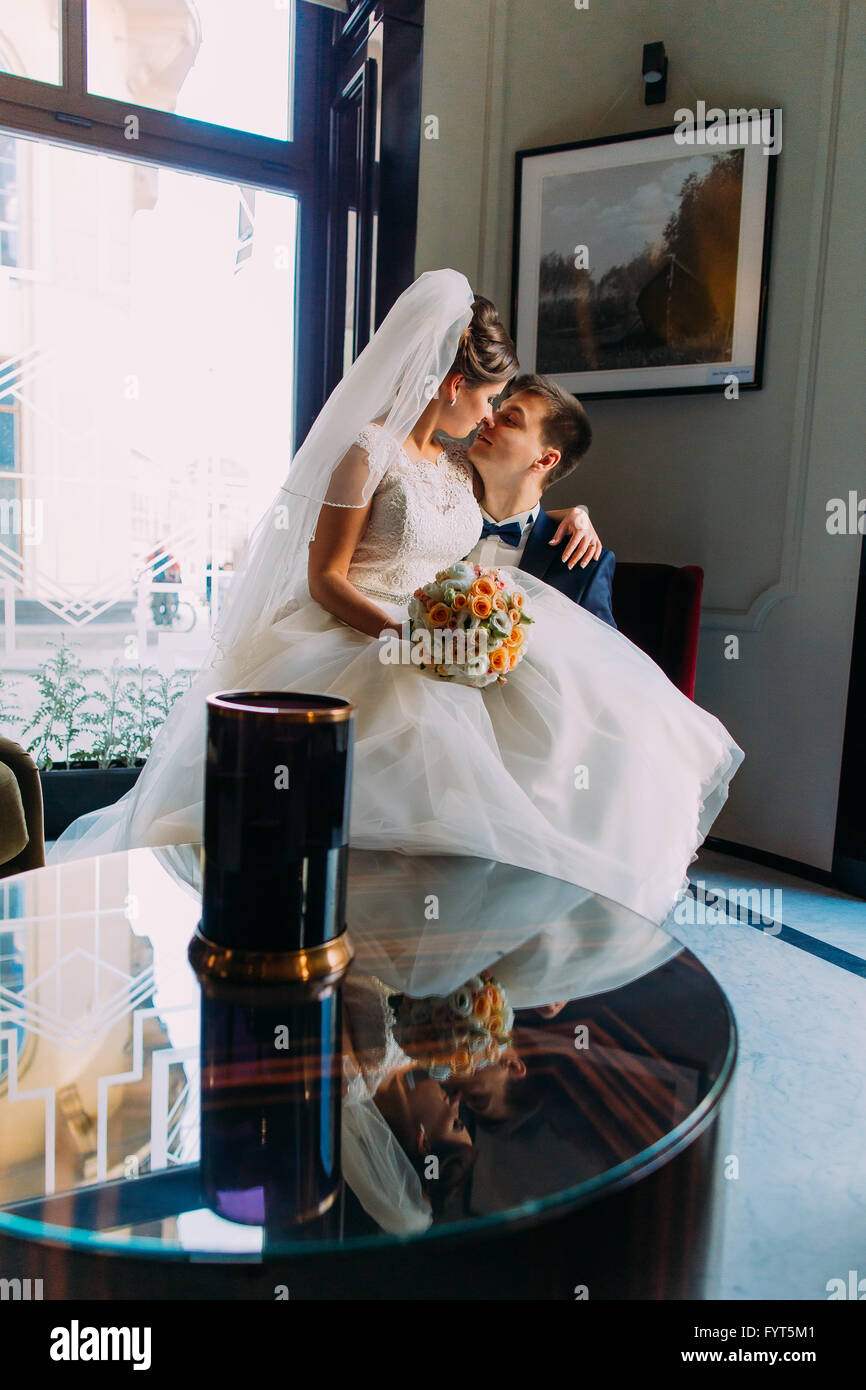 Bride and groom sitting in a luxurious chair on his knees Stock Photo ...