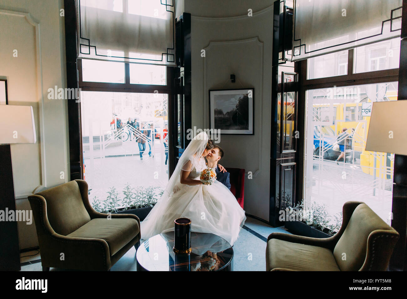 Bride and groom sitting in a luxurious chair on his knees Stock Photo ...