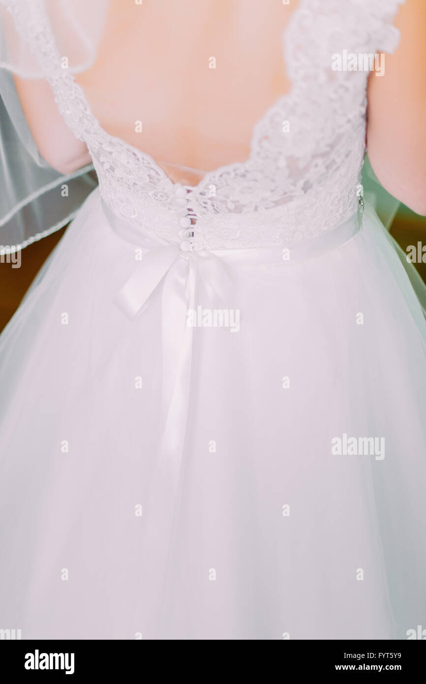 Beautiful bride in lace wedding dress standing with his back to the ...