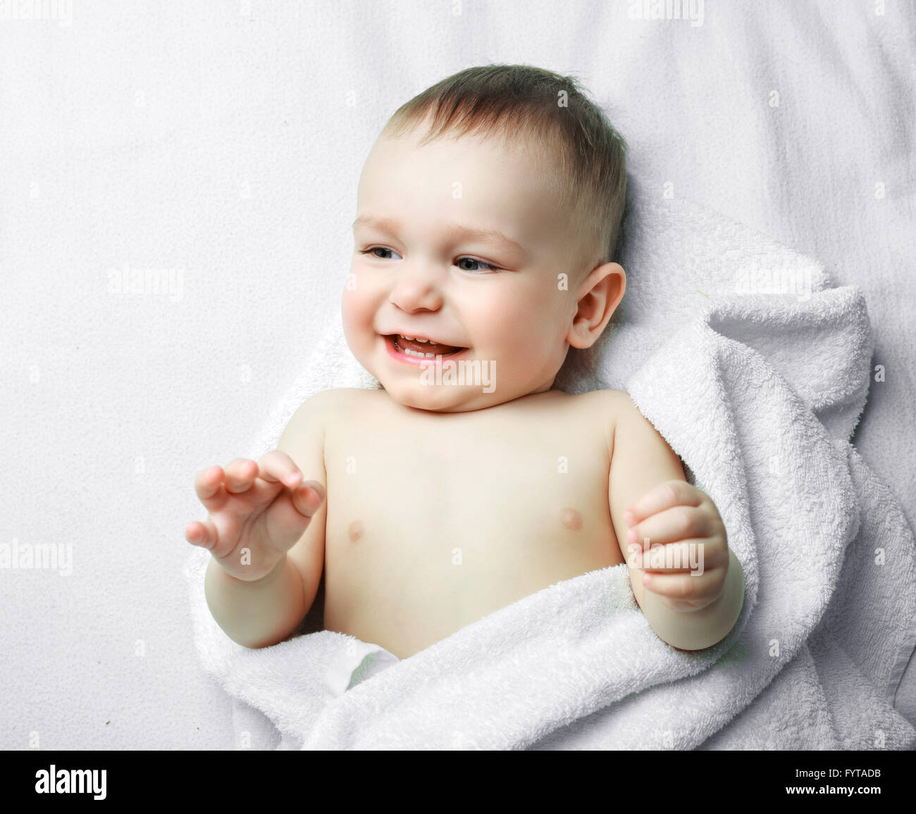 one year old baby with a towel in bed at home Stock Photo Alamy