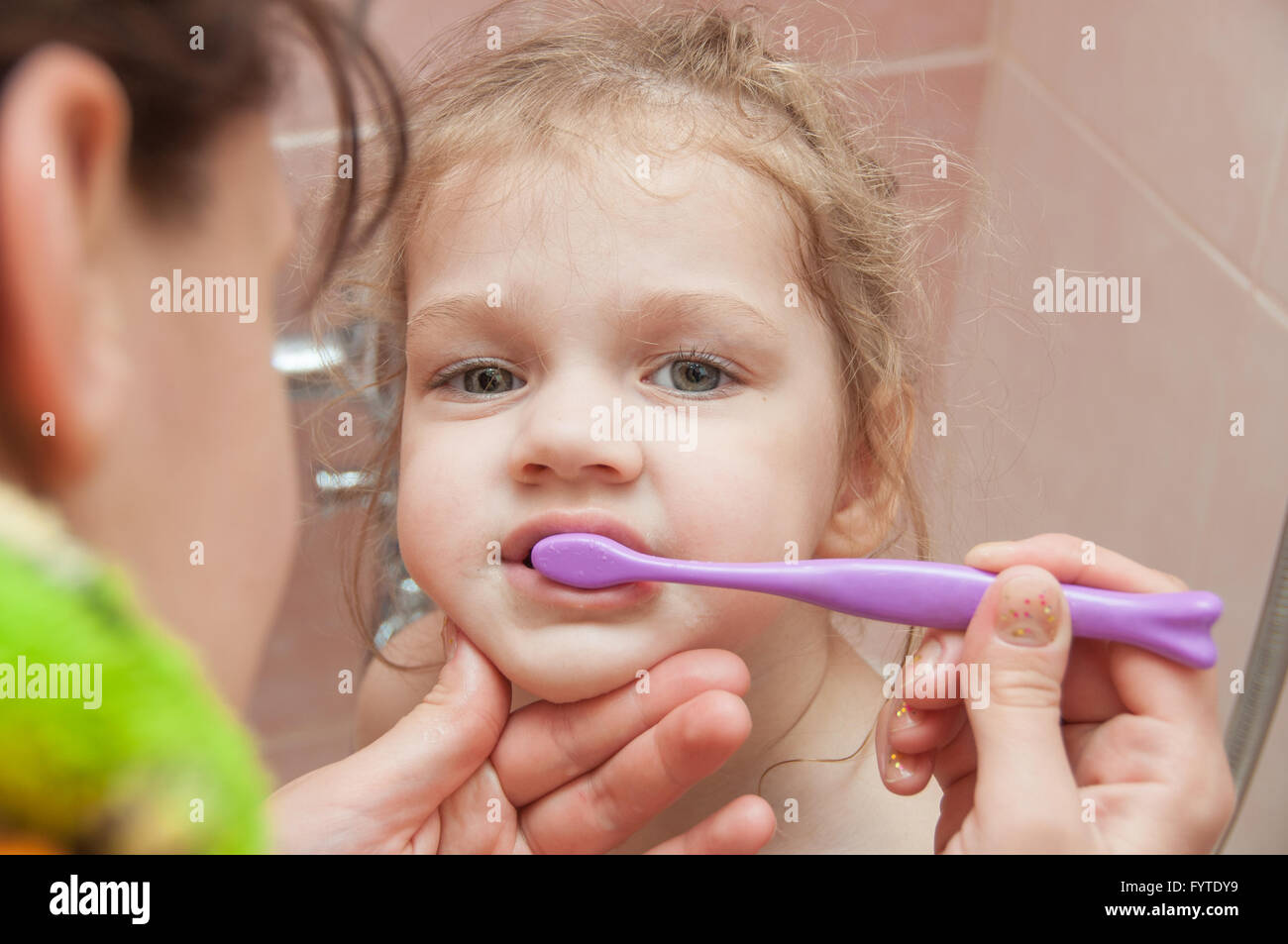 Mom helping girl brushing teeth Stock Photo