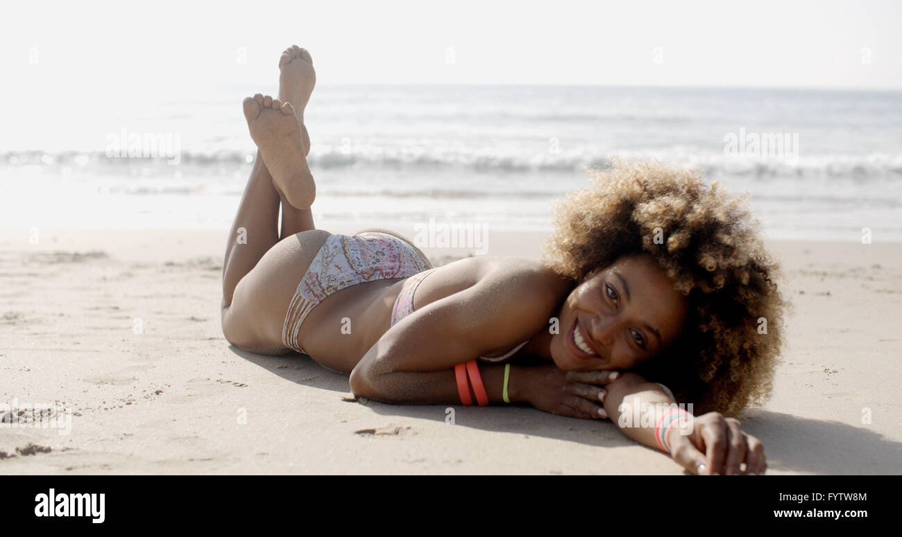 Woman In A Swimsuit Relaxing On The Sand Stock Photo