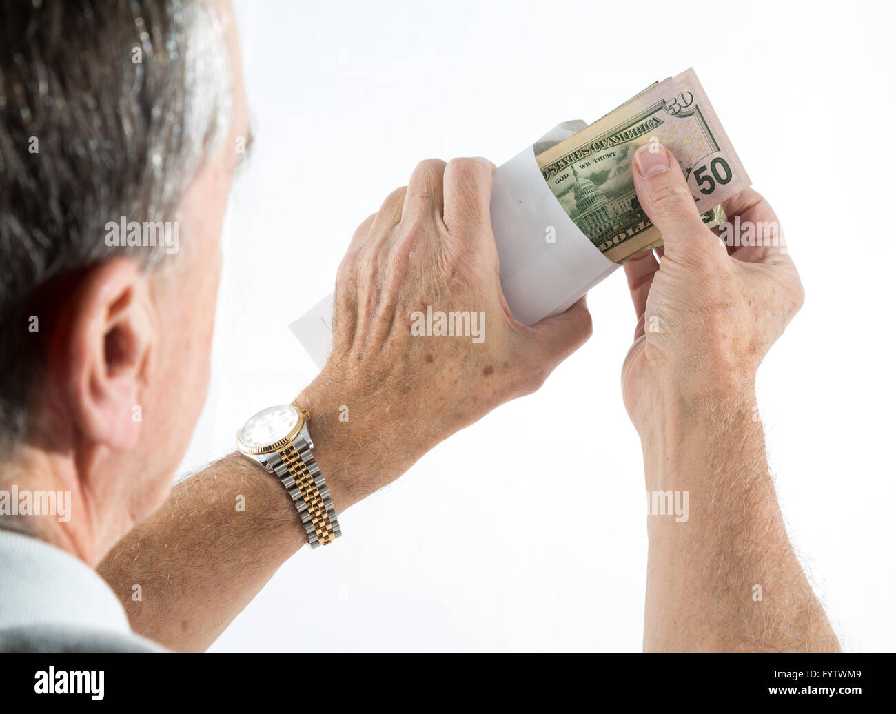 Caucasian ethnicity hands putting fifty dollar bills in envelope Stock Photo