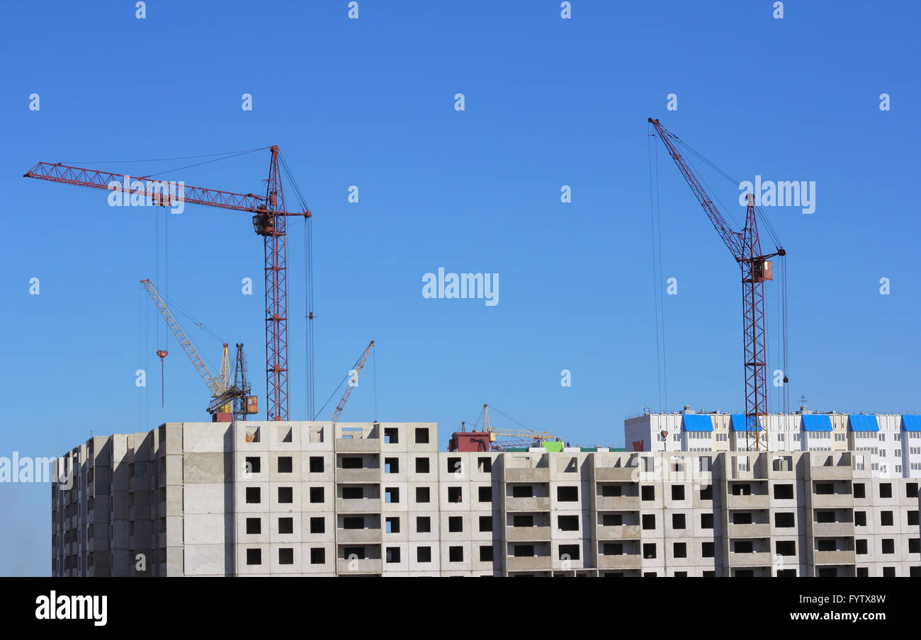 Industrial landscape with silhouettes of cranes on the sky background Stock Photo