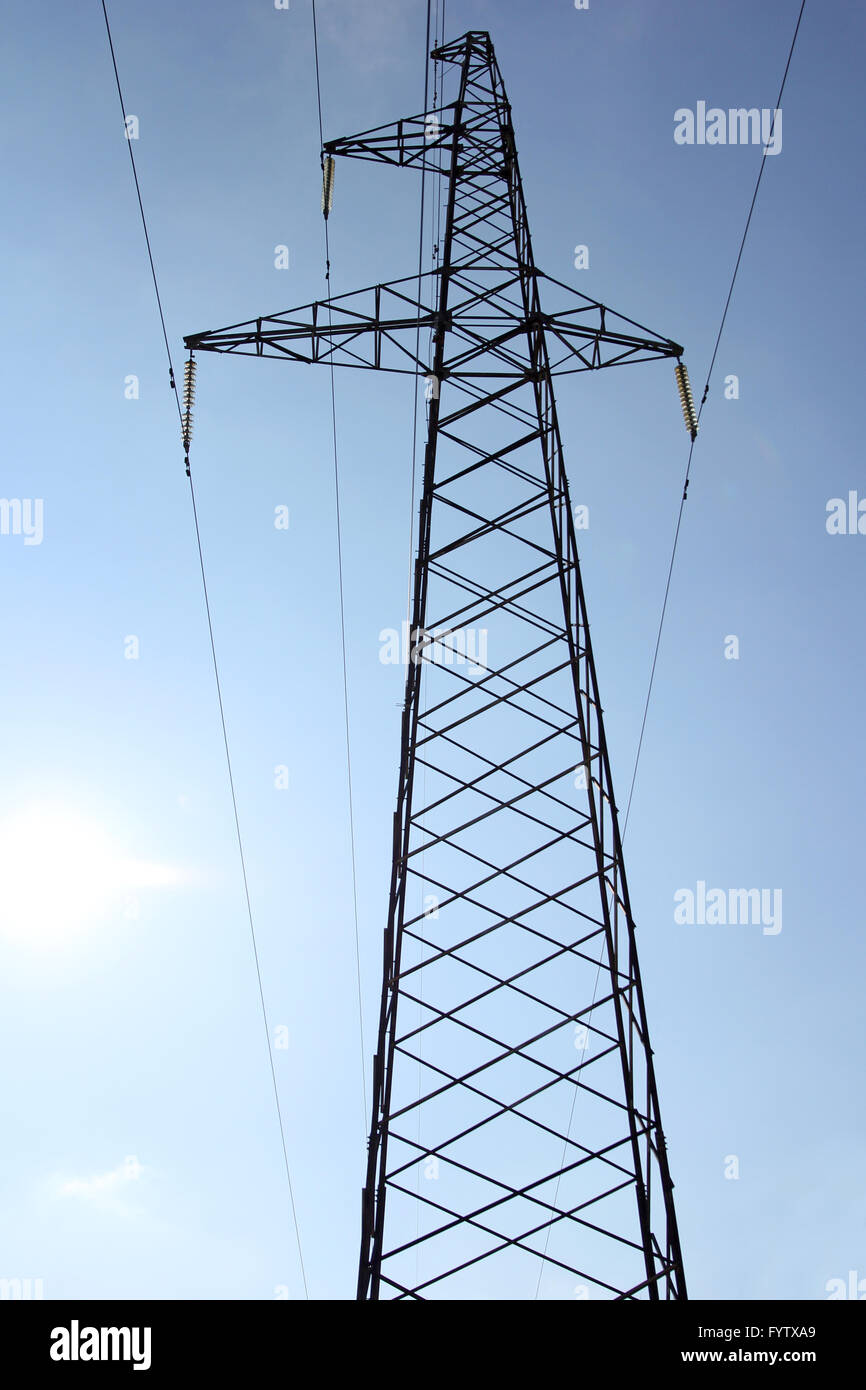 High voltage power pylons against blue sky Stock Photo