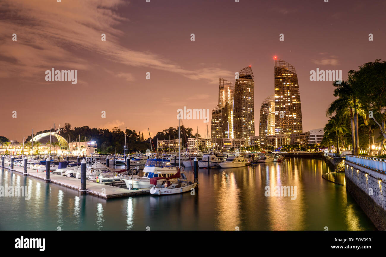 Keppel Bay marina and the Reflections residential complex at night in Singapore Stock Photo