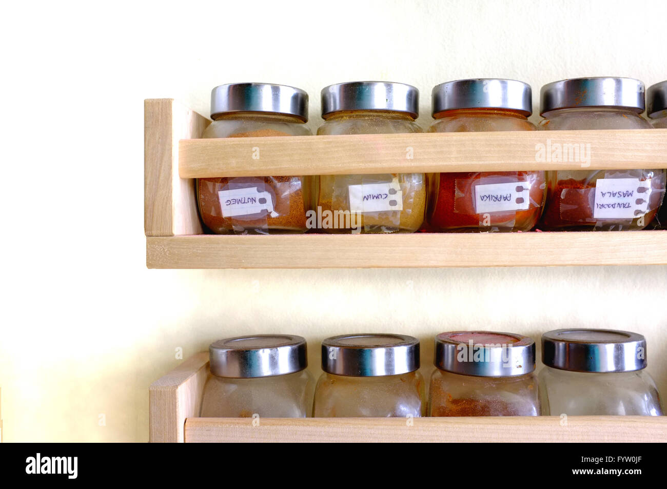 Shelves containing jars of spices and herbs attached to a kitchen wall Stock Photo Alamy