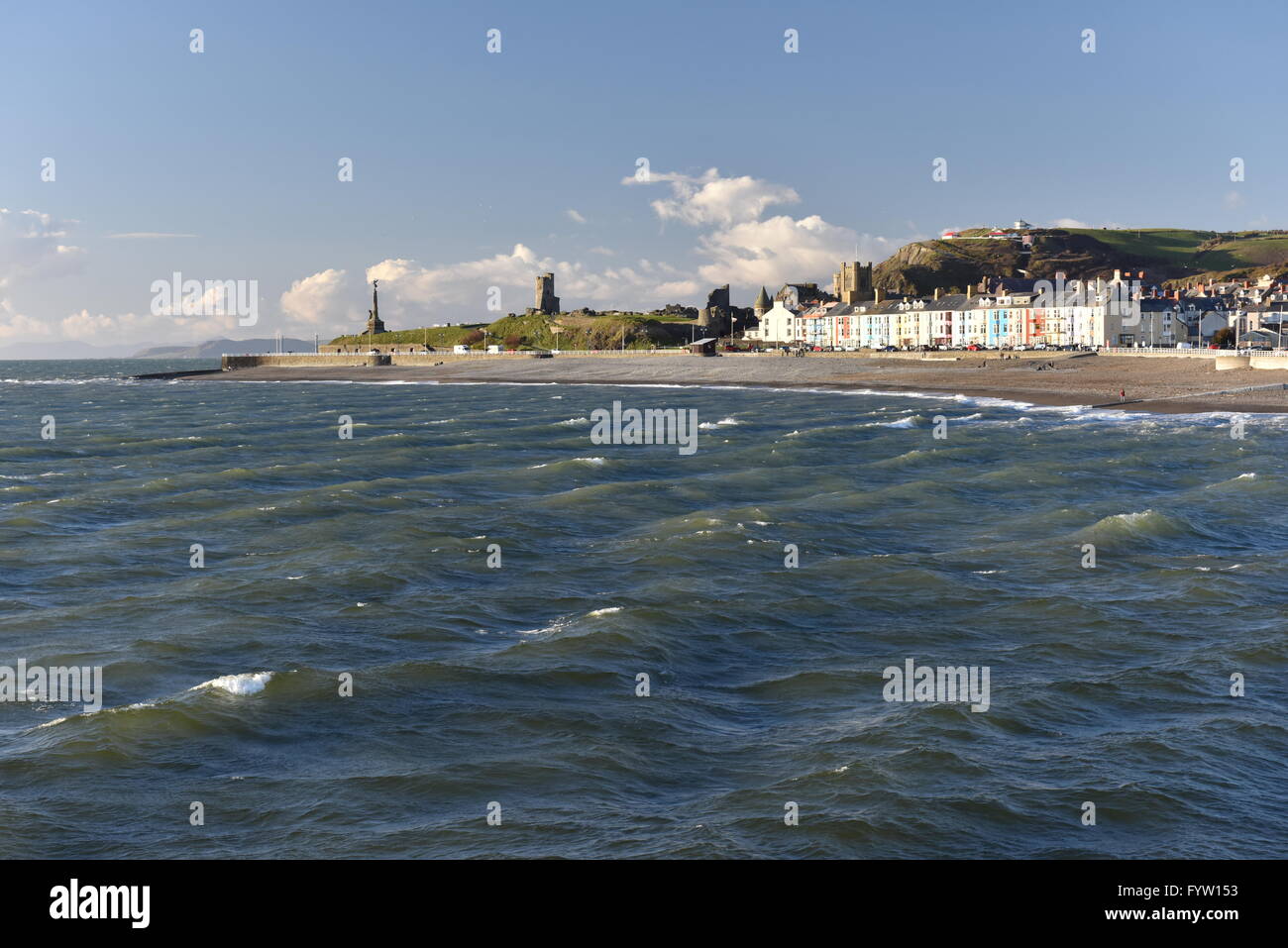 Looking north towards Aberystwyth in Cardigan Bay from Tanybwlch beach in the evening just before sunset, showing the Castle and Constitution Hill. Stock Photo