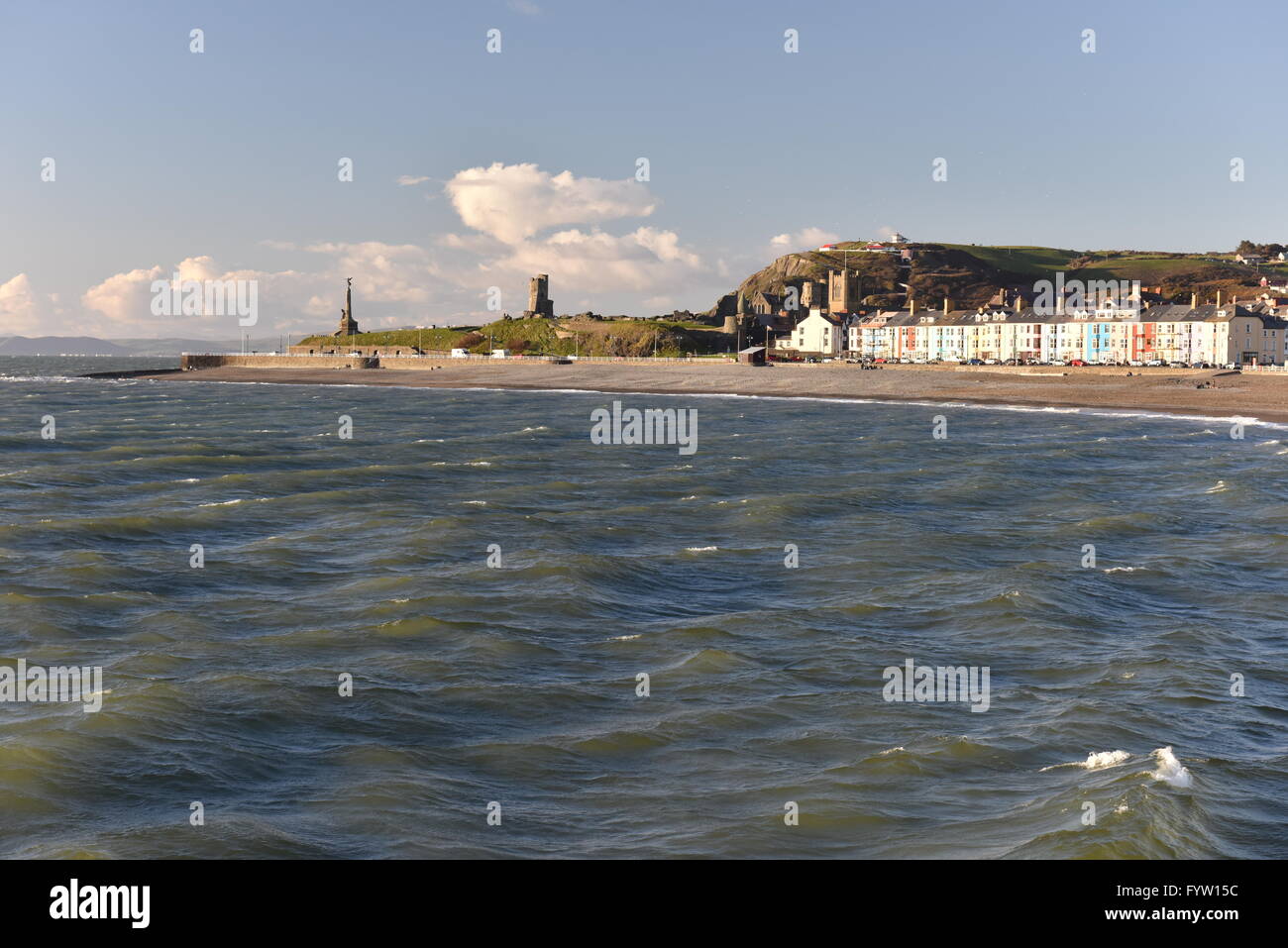 Looking north towards Aberystwyth in Cardigan Bay from Tanybwlch beach in the evening just before sunset, showing the Castle and Constitution Hill. Stock Photo