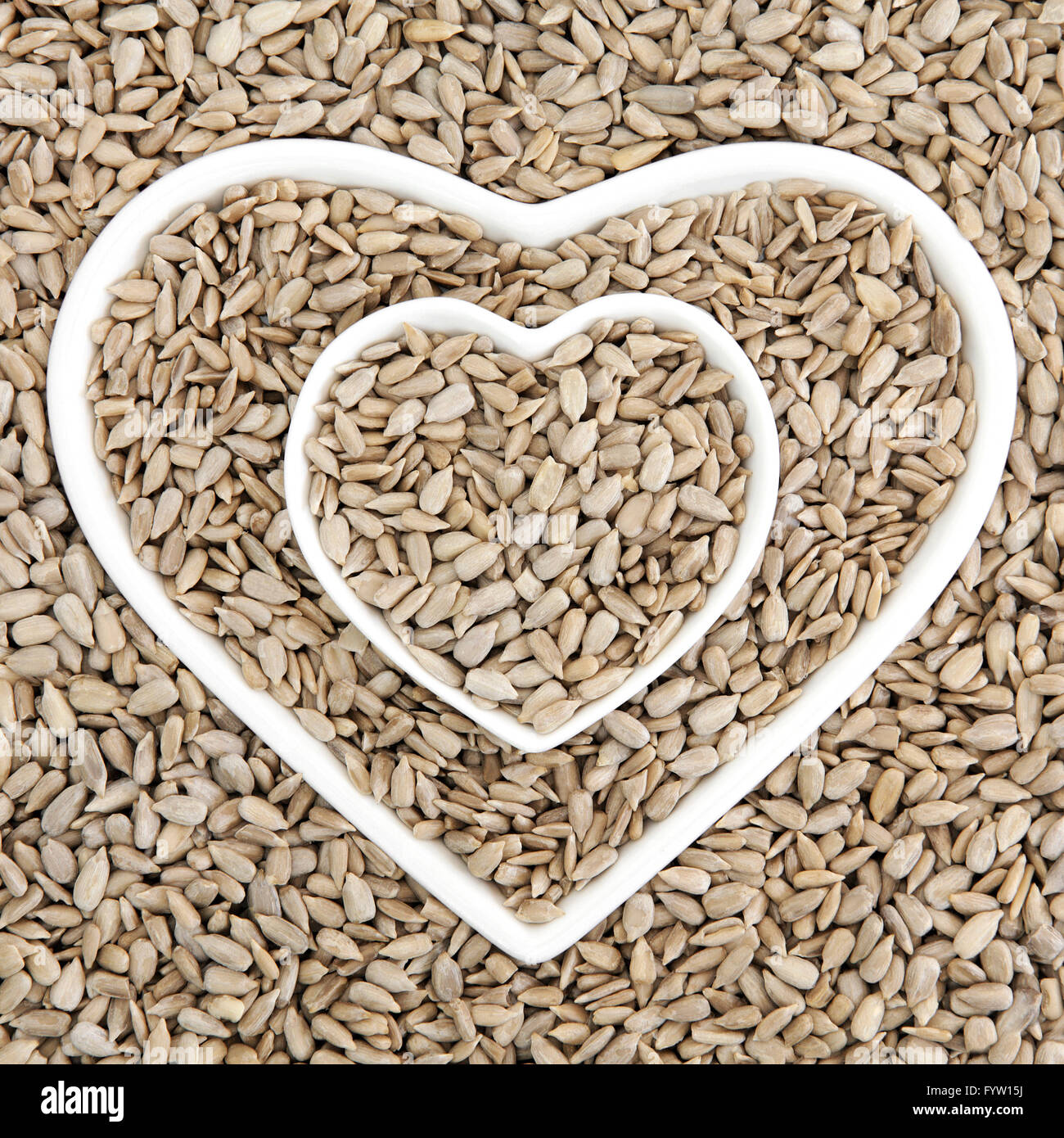 Sunflower seed health food in heart shaped porcelain bowls forming an