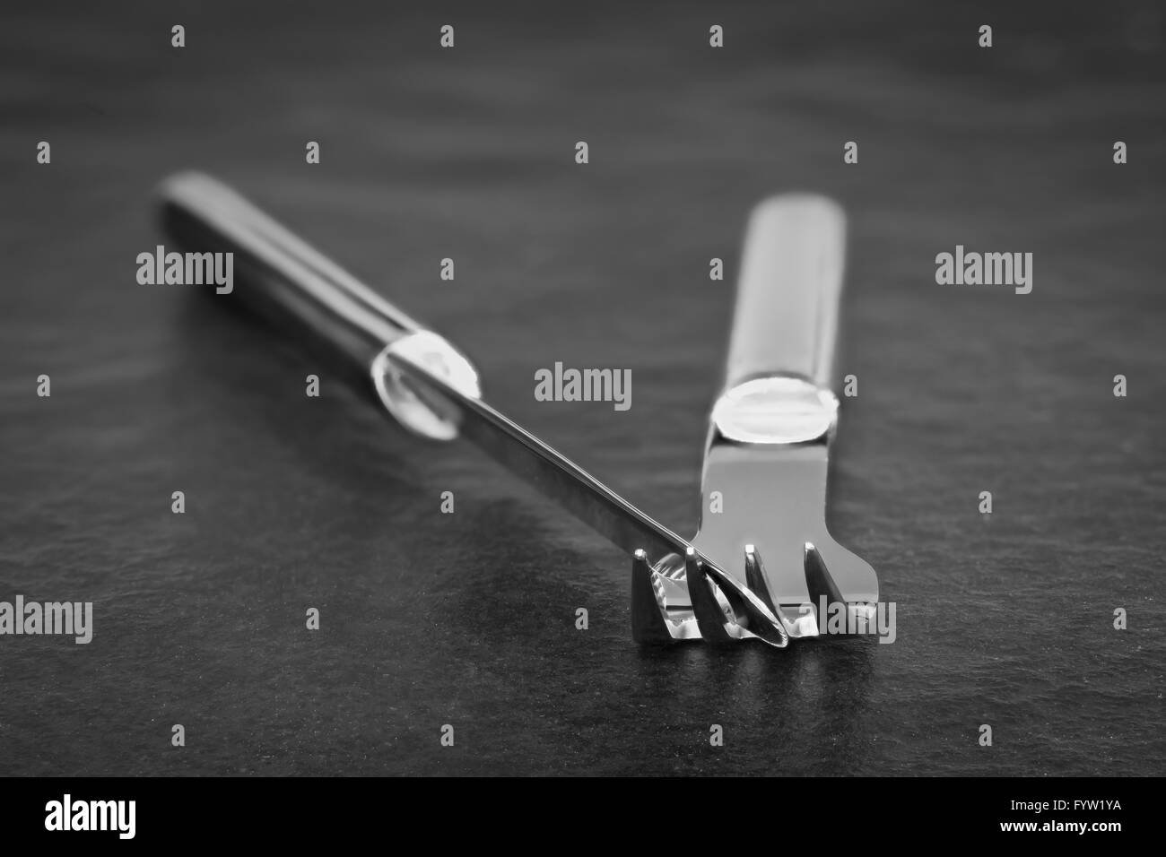 silvery-knife-and-fork-of-metal-on-a-stone-plate-stock-photo-alamy