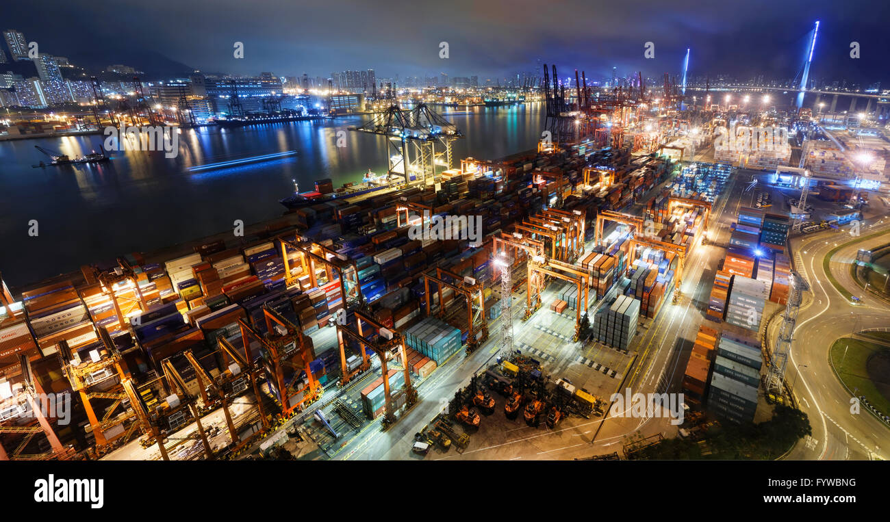 Cargo ship and crane at port reflect on sea bay, hong kong twilight ...