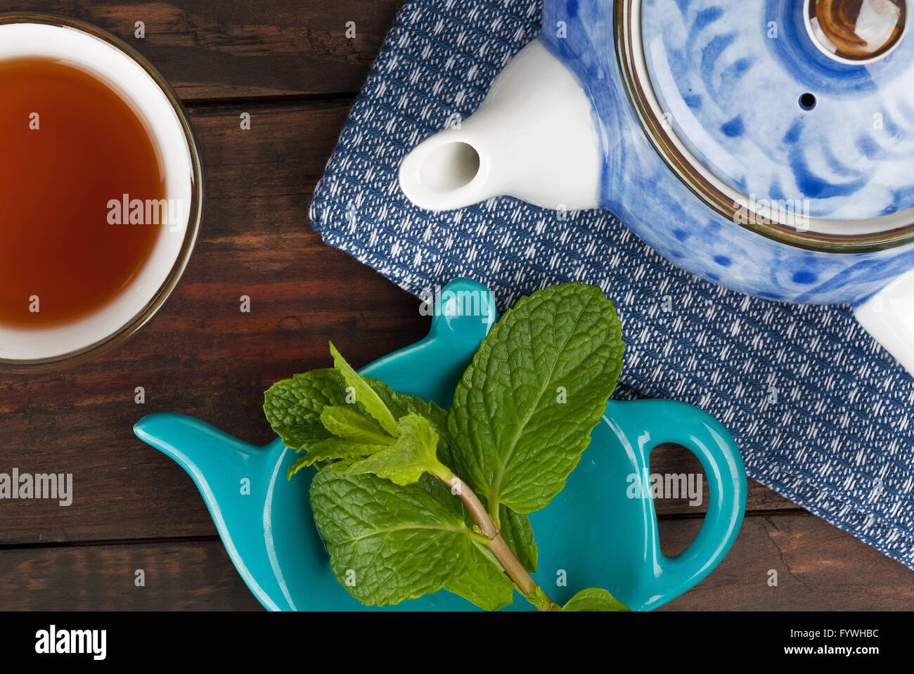 Closeup of teapot with cup, tea, and mint. Top view Stock Photo