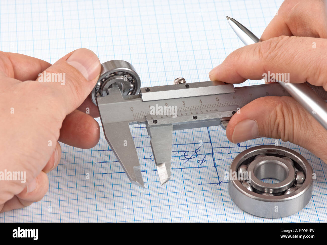 Technical drawing and callipers with bearing in hand Stock Photo - Alamy