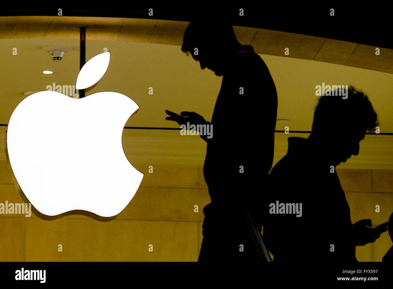 New York, USA. 28th Apr, 2016. People check their cellphones outside the Apple store at the Grand Central Terminal in New York, United States, April 28, 2016. Apple Inc. on Tuesday released fiscal results for the second quarter of 2016, which showed the first year-over-year slump of both quarterly revenue and profit since 2003 and the first ever drop in iPhone sales. © Li Muzi/Xinhua/Alamy Live News Stock Photo