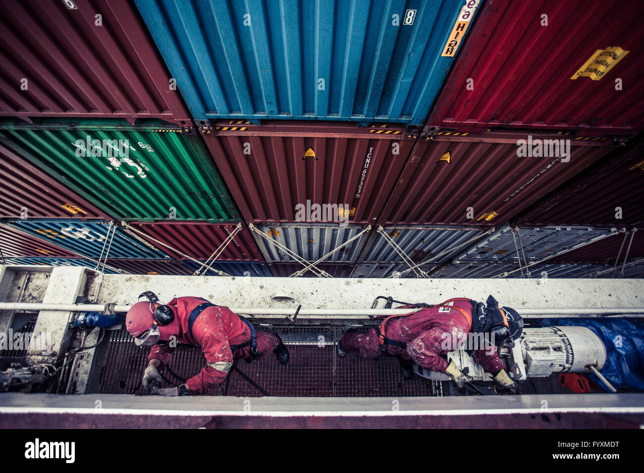 Workers maintaining a container ship while at sea Stock Photo