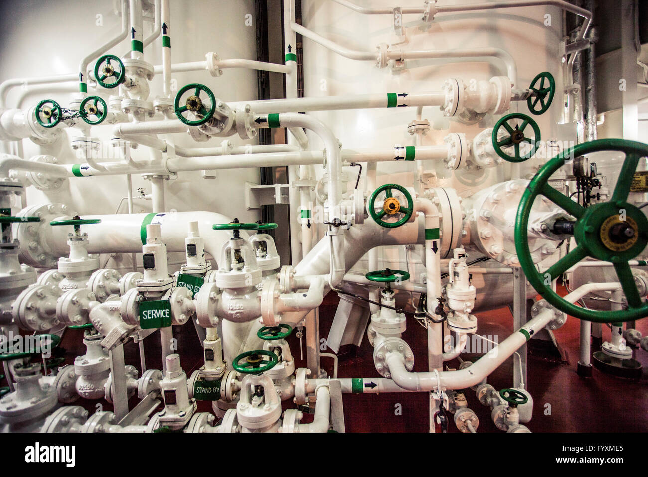 Maze of pipes dedicated to life support systems on board a container ship. Stock Photo